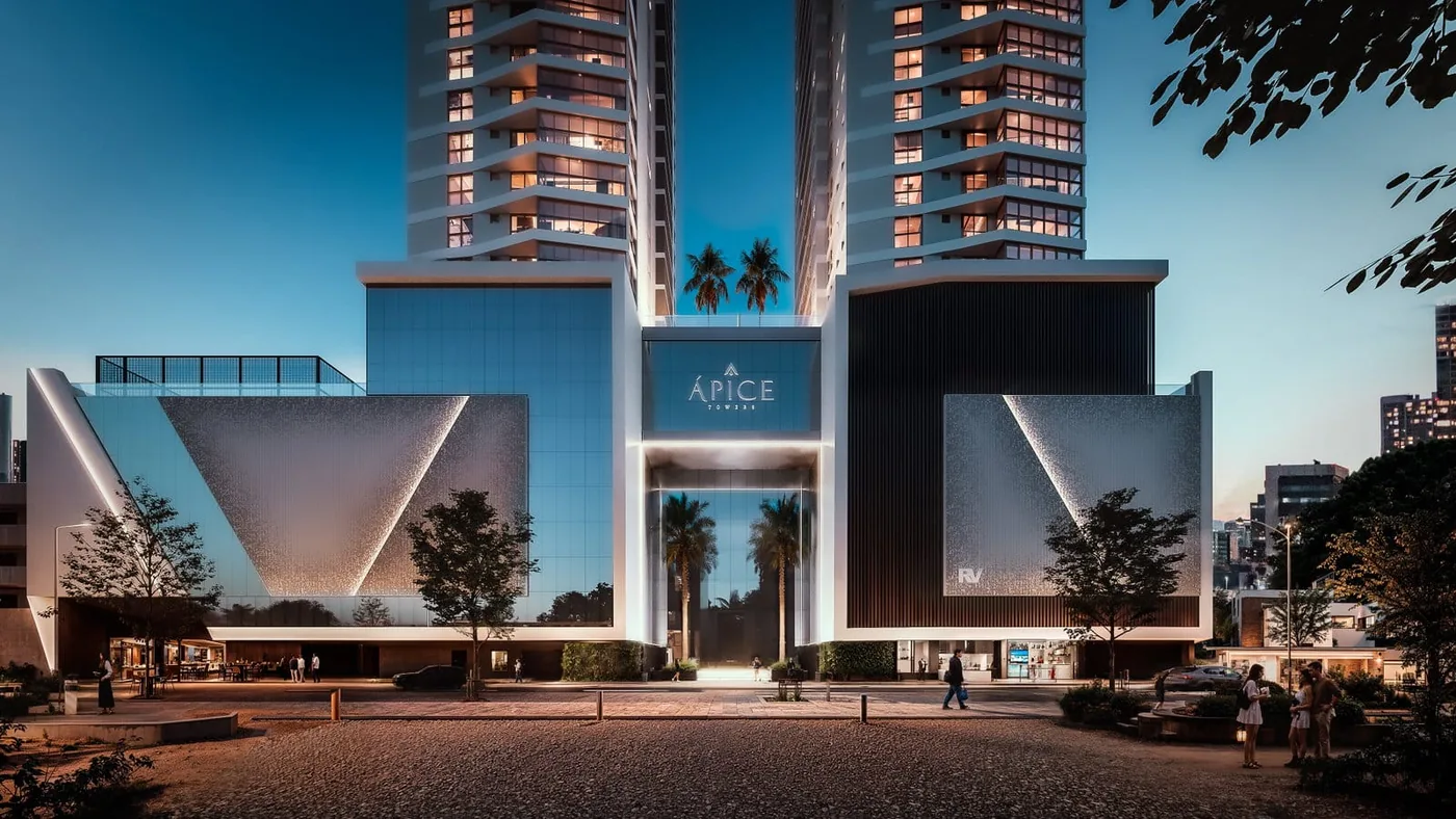 O embasamento do Ápice ao anoitecer, com o letreiro do empreendimento iluminado entre as duas torres e palmeiras na entrada