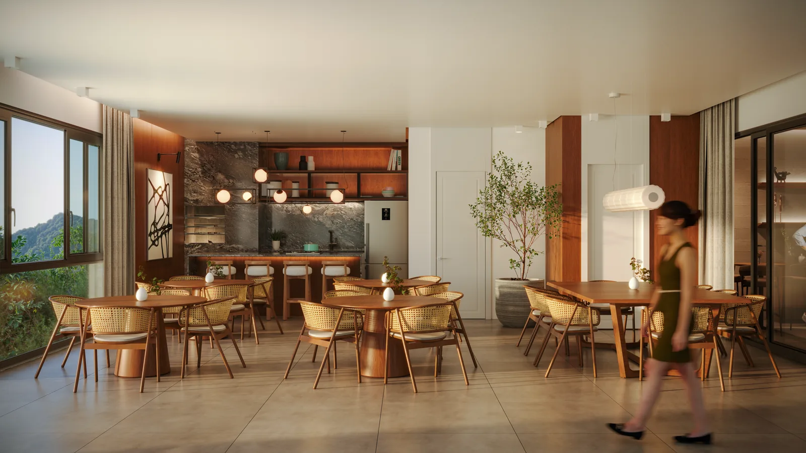 Espaço gourmet com mesas redondas de madeira, cadeiras de palha, balcão de apoio ao fundo e árvore em vaso junto da janela