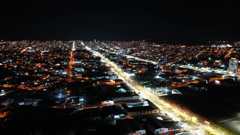 Vista aérea noturna de Chapecó, com as avenidas iluminadas cortando a cidade