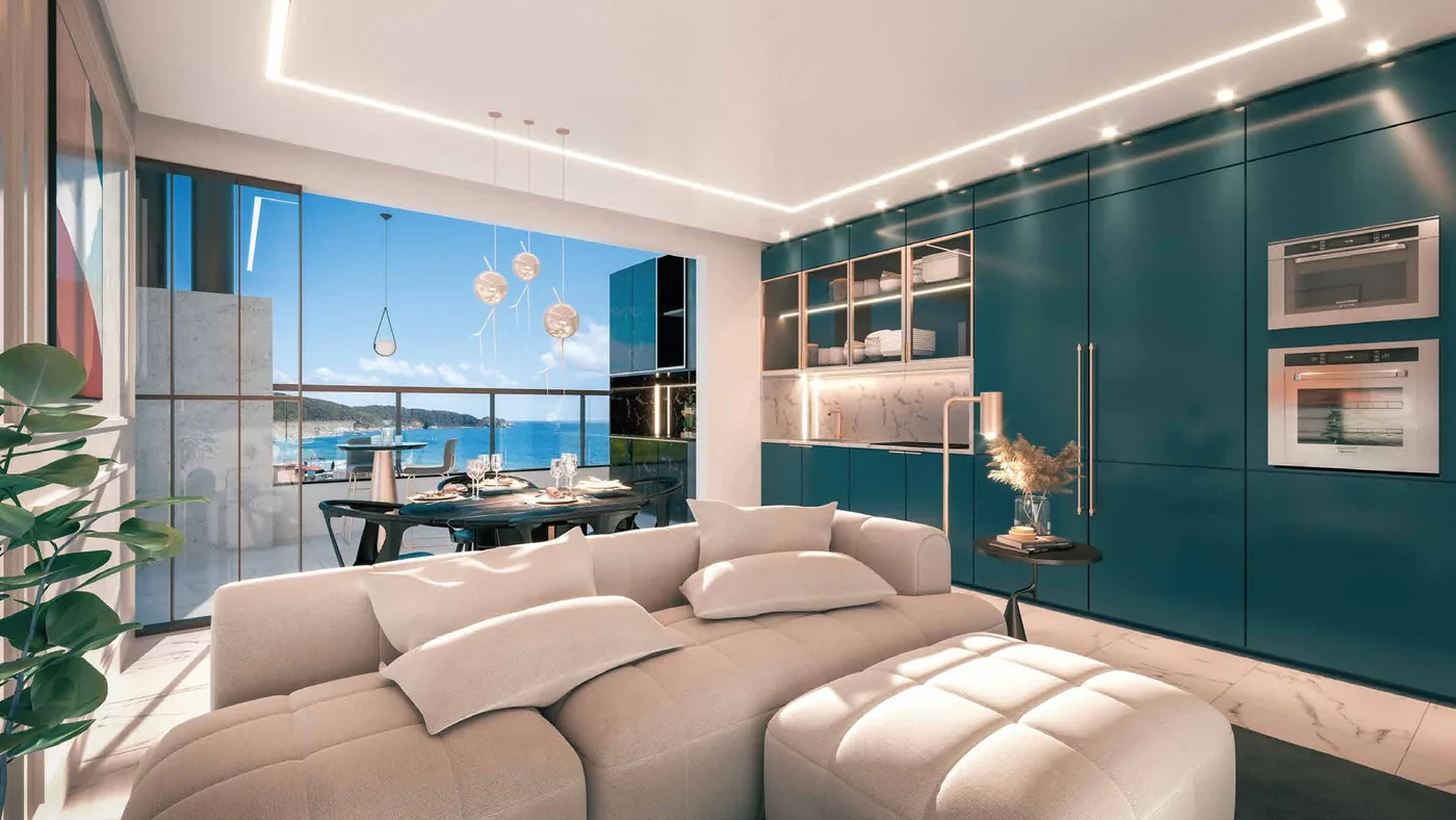 Living da cobertura, com sofá modular claro, marcenaria verde e esquadrias abertas para a vista do mar
