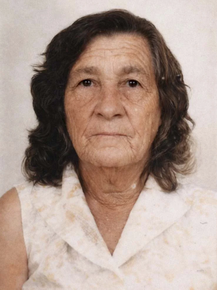 Retrato de Dona Enedina Mercedes, de cabelo escuro na altura dos ombros e blusa clara de gola, olhando para a câmera