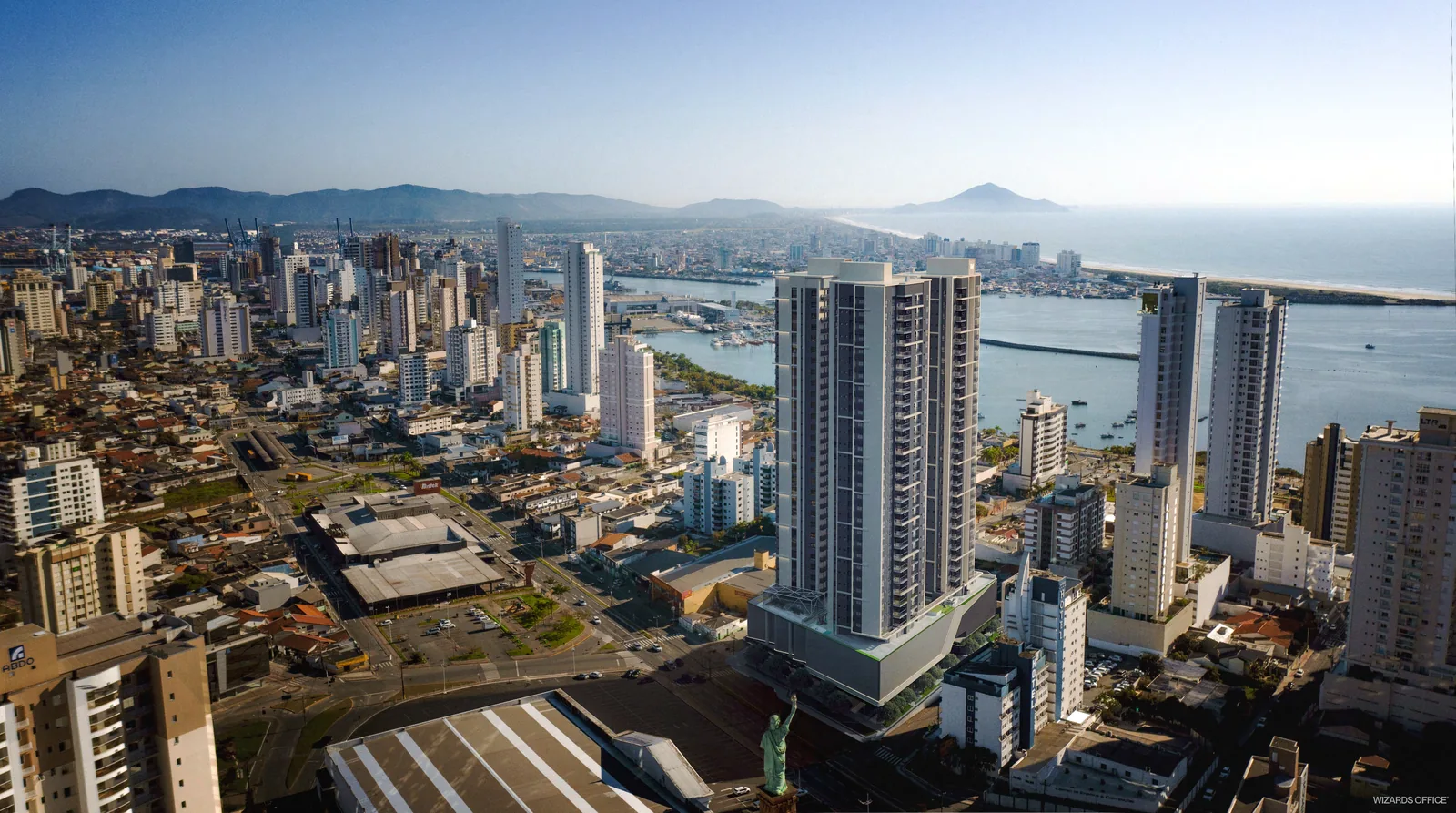 Vista aérea de Itajaí com as torres do Fazenda Garden inseridas no tecido do bairro, e o rio, o porto e o mar ao fundo