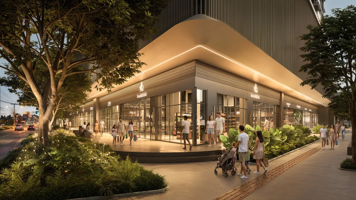 O mall ao anoitecer, com as vitrines iluminadas sob a marquise curva, árvore alta no passeio e pessoas caminhando