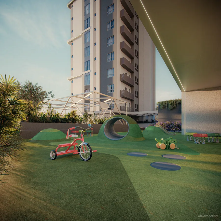 Parque infantil ao ar livre, com grama sintética, brinquedos baixos e triciclo, sob a marquise do embasamento