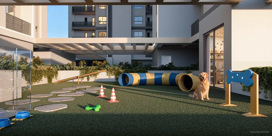 Espaço pet com grama sintética, túnel de agility, obstáculos coloridos e um cachorro no centro