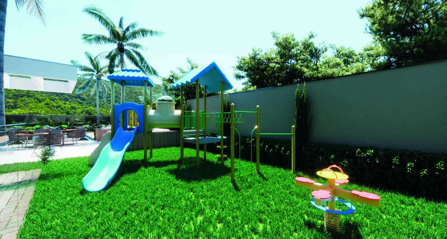 Playground sobre grama, com escorregador, trepa-trepa, gangorra e coqueiros atrás do muro