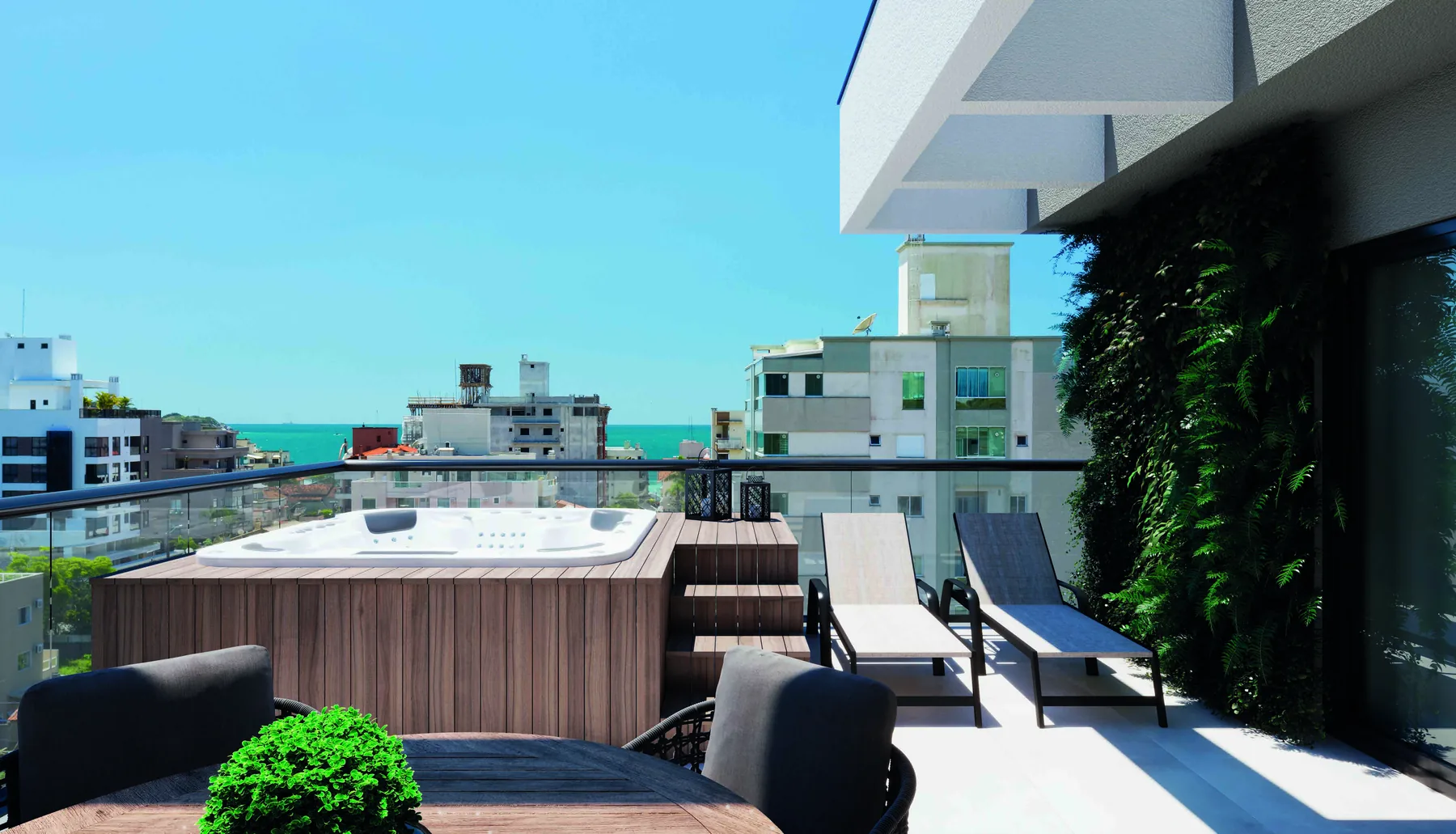 Terraço descoberto do duplex, com spa de madeira, espreguiçadeiras, jardim vertical na parede lateral e o mar ao fundo