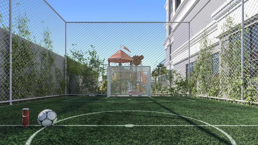 Quadra de futebol society com grama sintética, alambrado e vegetação na lateral