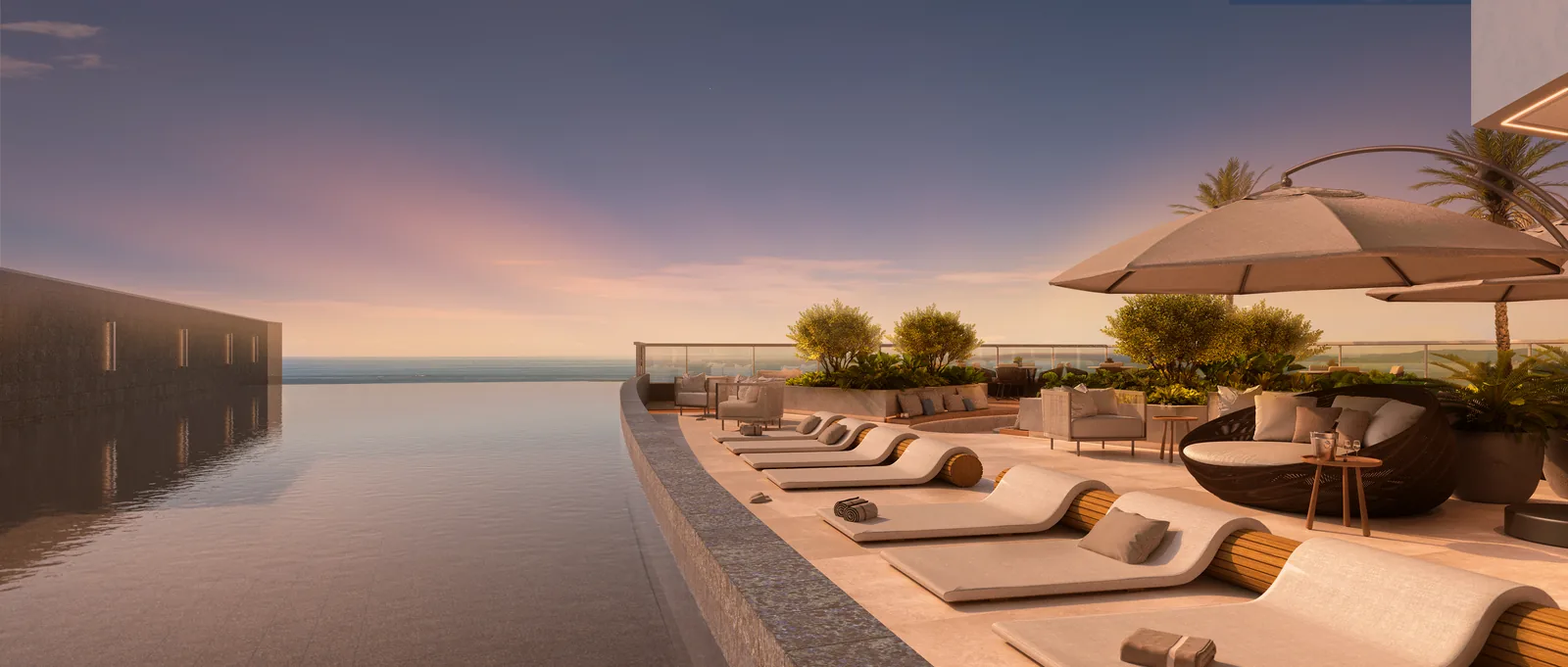 Piscina de borda infinita do Marine ao entardecer, com a lâmina de água se encontrando com o mar ao fundo, espreguiçadeiras curvas e guarda-sóis no deck