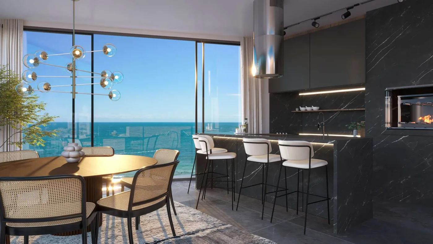 Living do T-02 em tom escuro, com mesa de jantar redonda, banquetas na bancada de mármore e a janela de canto para a praia