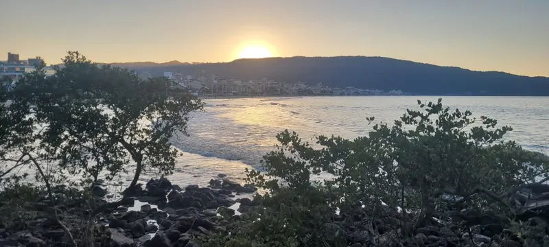 Pôr do sol sobre baía abrigada no litoral de Santa Catarina