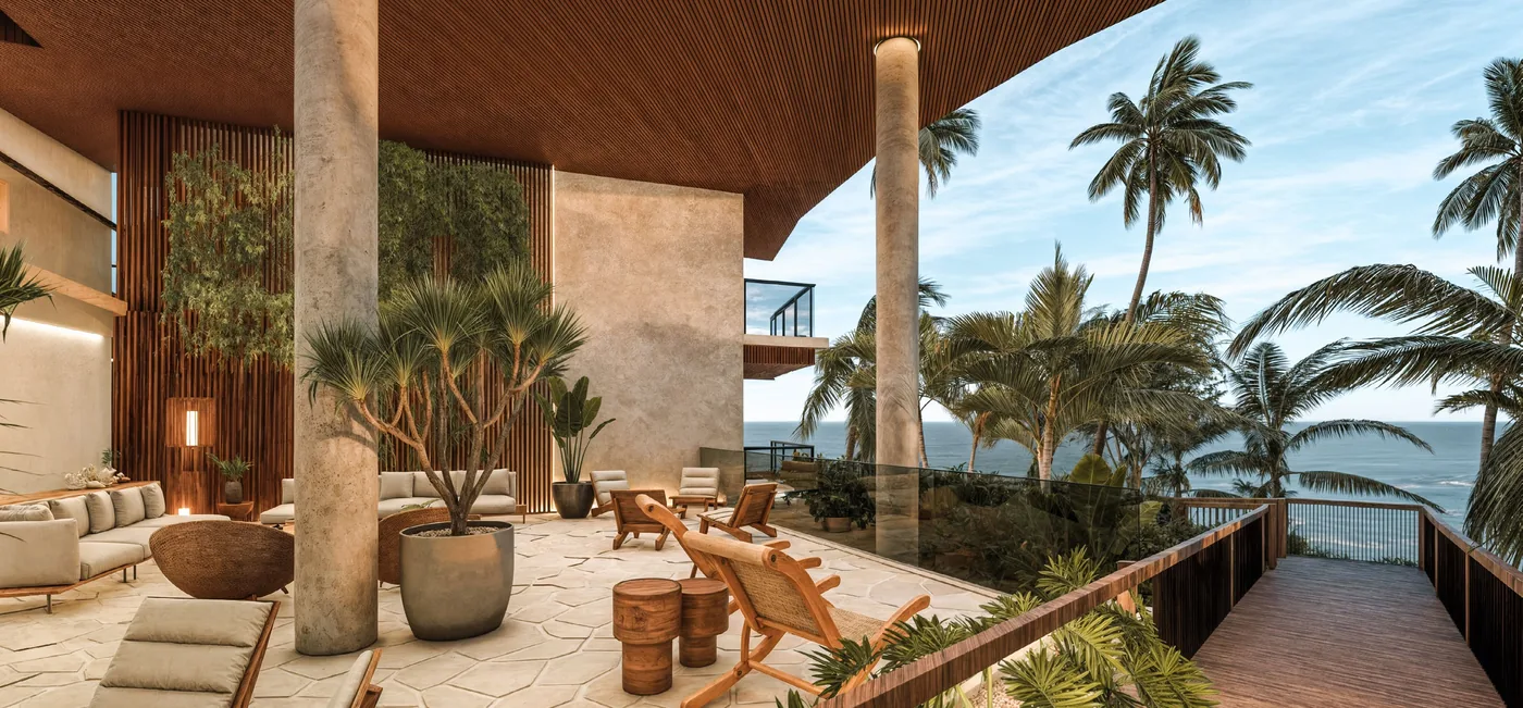 Lounge de pé-direito duplo aberto para a Praia do Ribeiro, com poltronas, vasos de palmeiras e a passarela de madeira descendo para a areia
