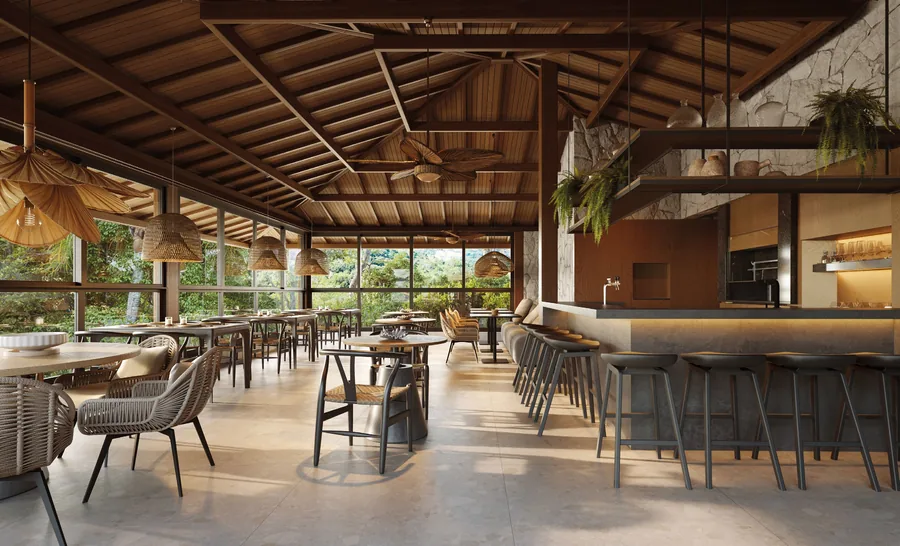 Restaurante privativo de pé-direito alto com estrutura de madeira aparente, mesas postas e balcão de bar ao fundo