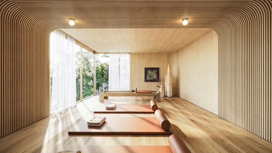 Sala de pilates em madeira clara, com luz natural vinda de uma abertura alta