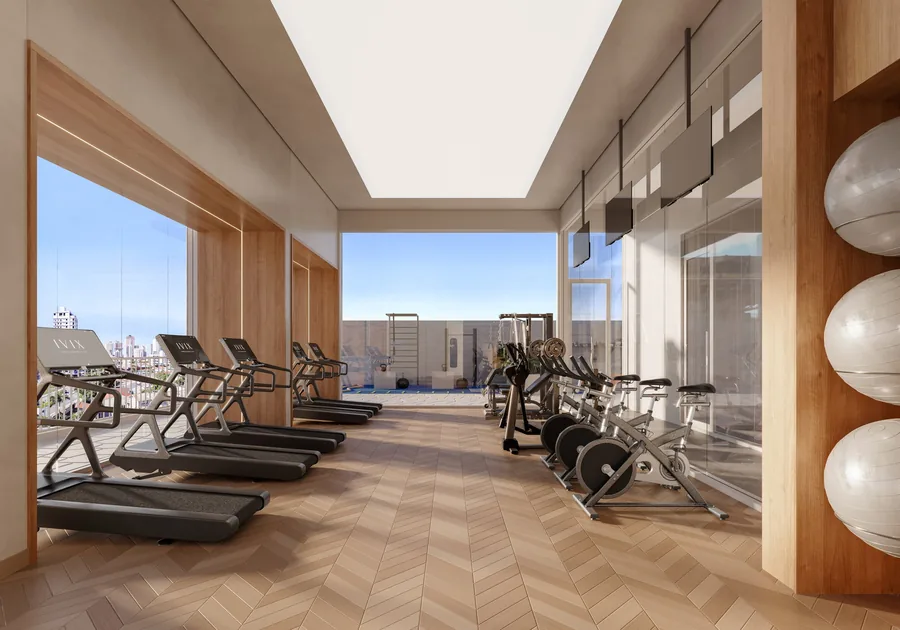 Academia com esteiras alinhadas diante das janelas, bicicletas, aparelhos de musculação e bolas de pilates nos nichos