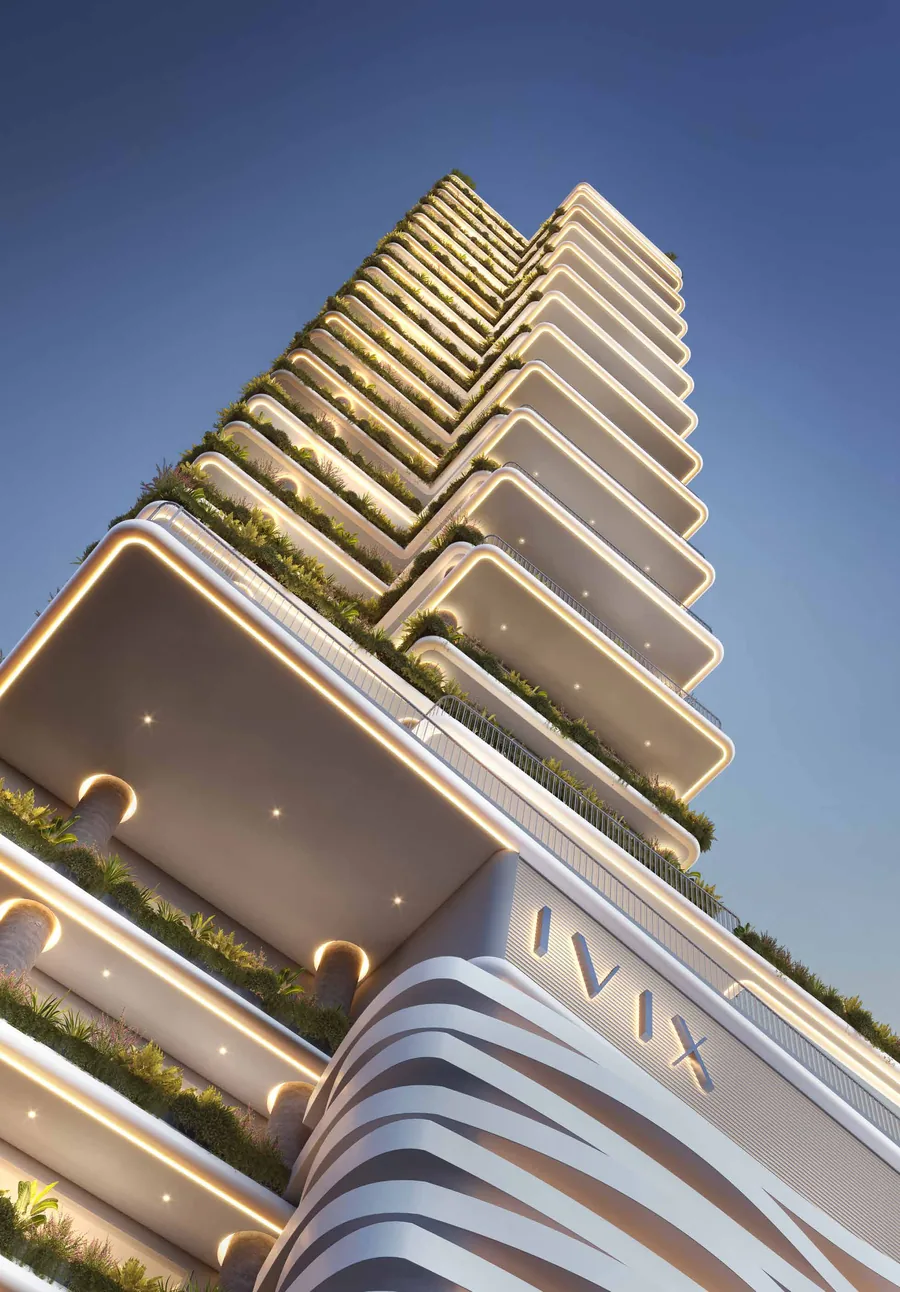 O coroamento da torre do Velta visto de baixo, com as sacadas em curva subindo e o letreiro da IVIX Empreendimentos no topo