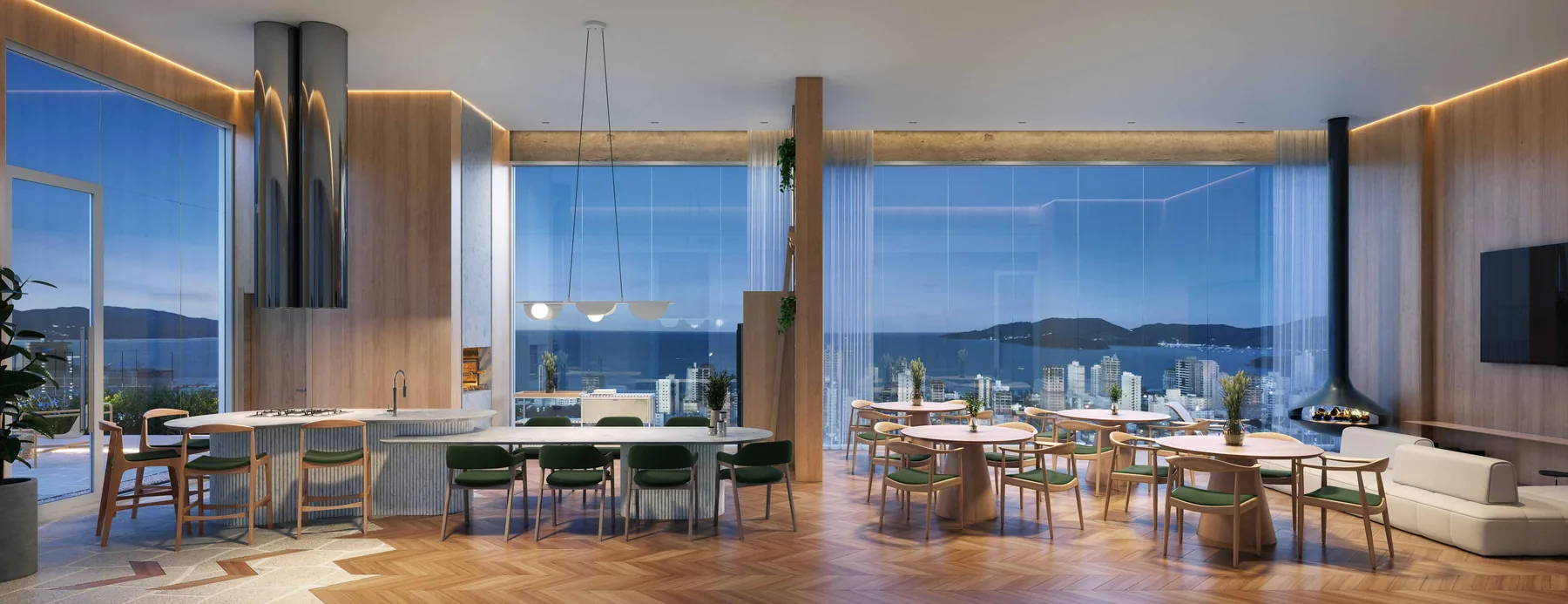 Salão de festas II em vista panorâmica, com mesas postas, cozinha de apoio à esquerda e janelas do piso ao teto para o mar e os morros