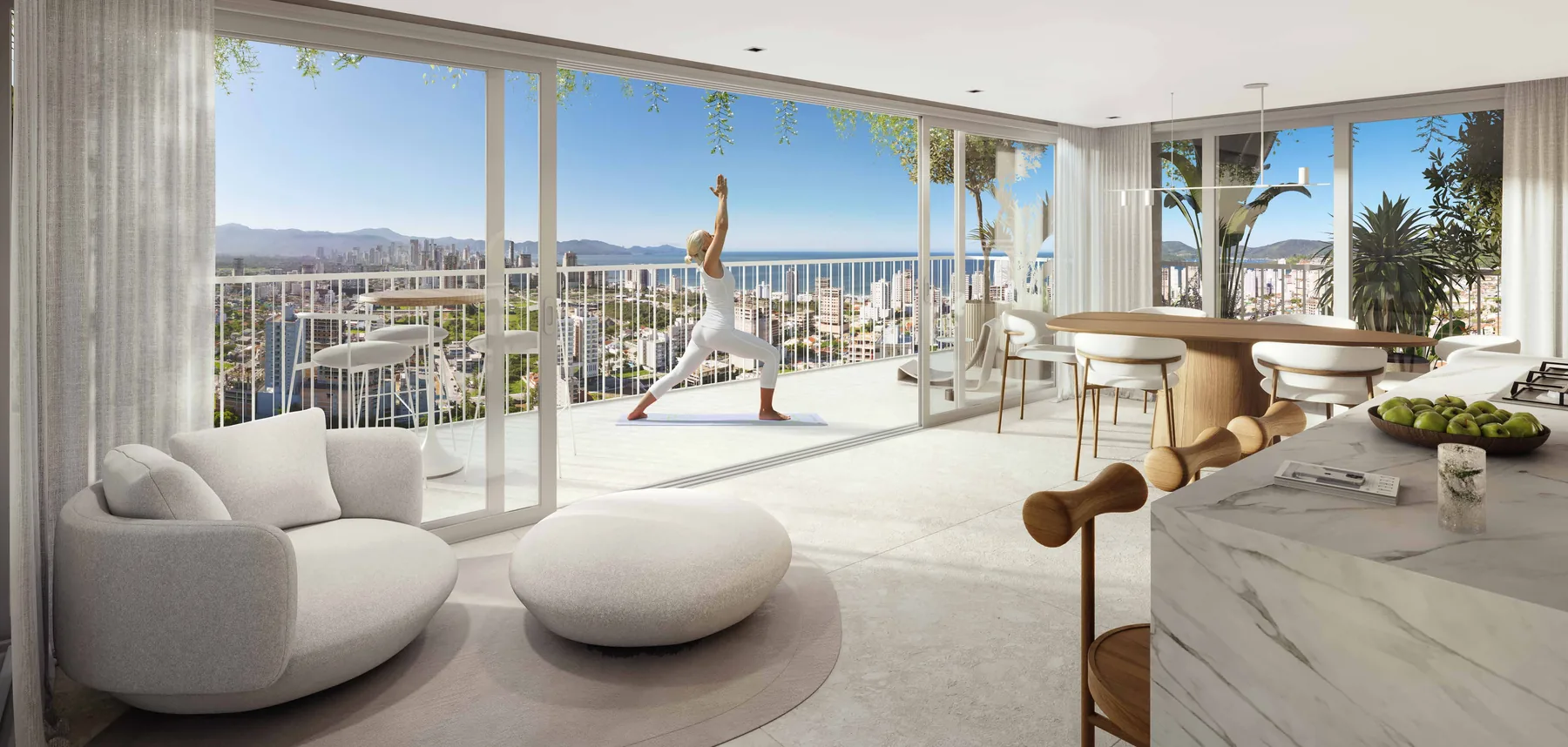 Living do apartamento tipo 1 em vista ampla, com estar claro à esquerda, pilar roliço no meio e a sacada envidraçada para a cidade e o mar