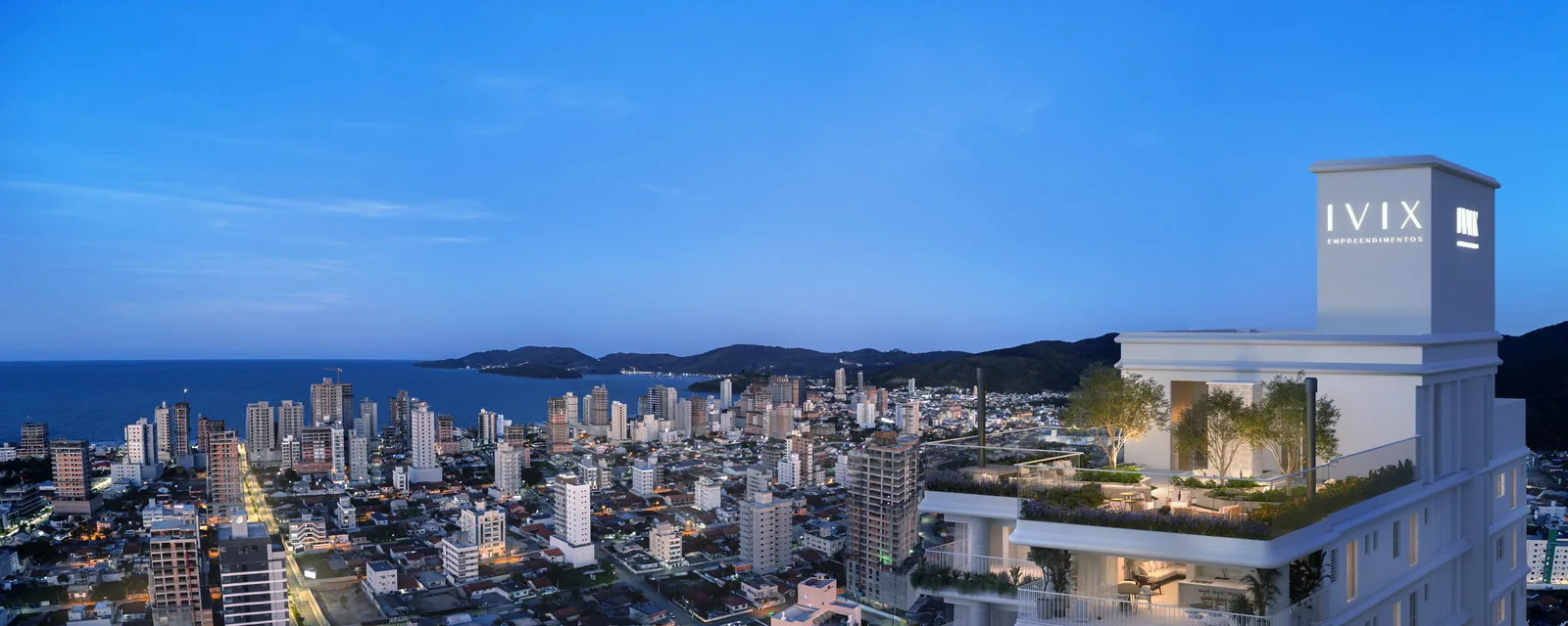 O rooftop do Velta no fim da tarde, com jardins e espelho de água no topo da torre, a cidade acesa embaixo e o mar ao fundo