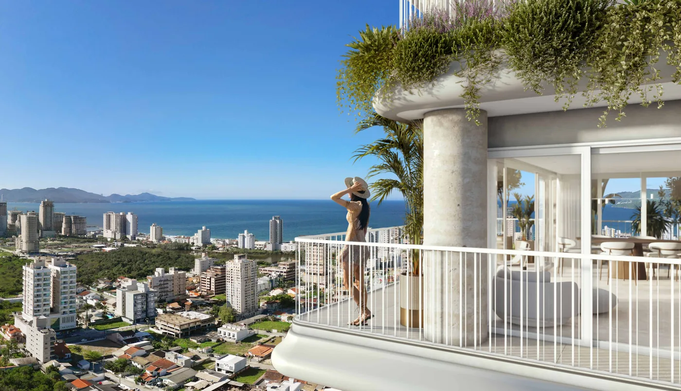 Pessoa na sacada de um apartamento do Velta, de frente para a cidade baixa, a orla e as ilhas no horizonte