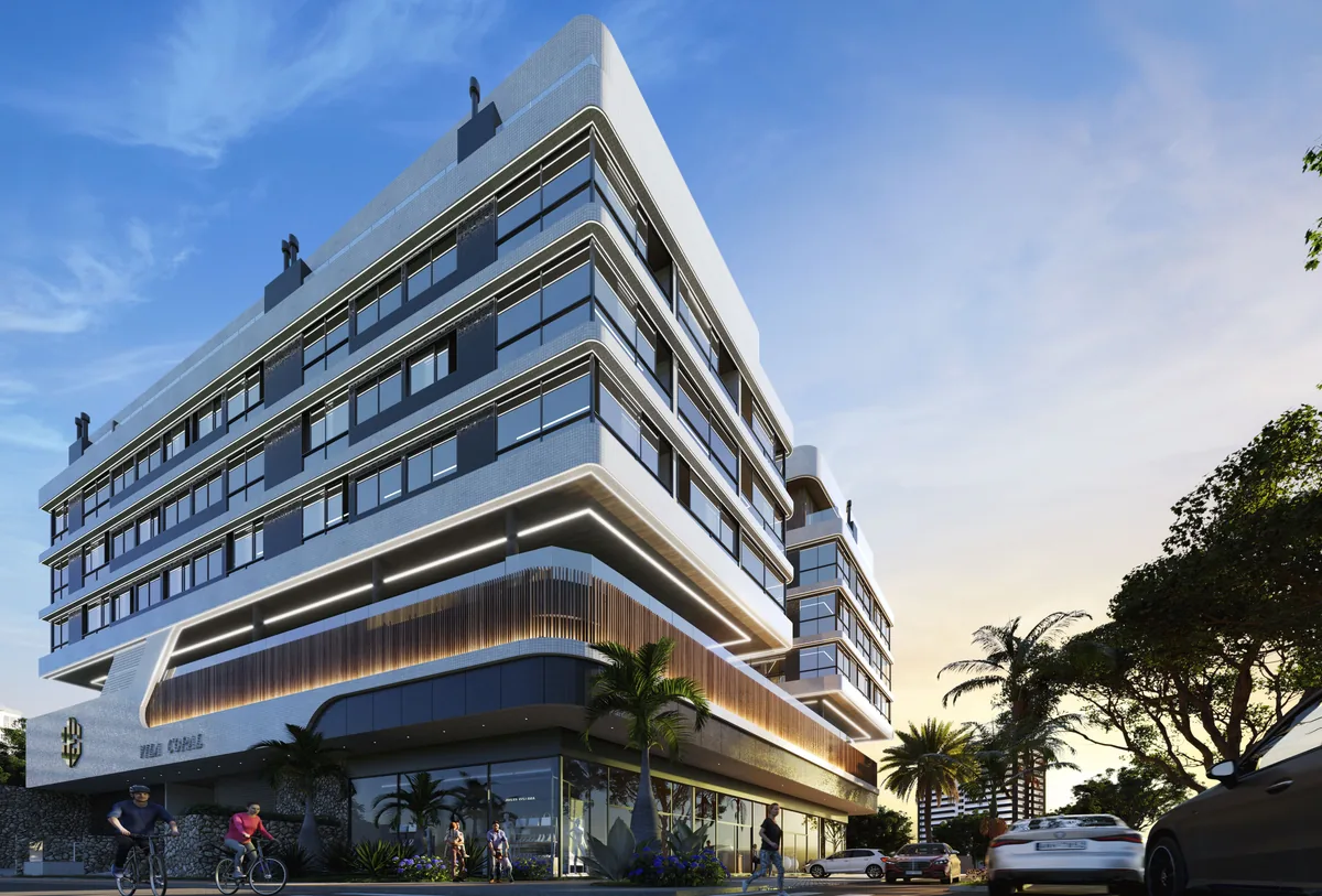 A fachada do Villa Coral vista da esquina, com as varandas curvas, o embasamento comercial e palmeiras no passeio