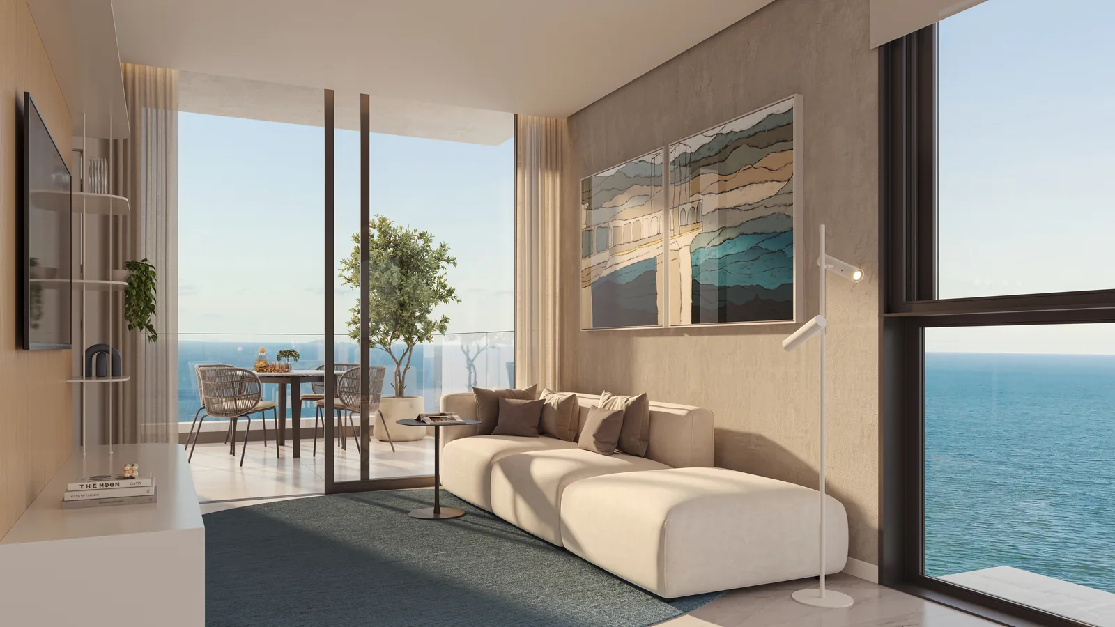 Sala de estar de um apartamento de esquina do Vivatto, com sofá modular claro, tapete azul, janelas para o mar em duas faces e a varanda com mesa ao lado